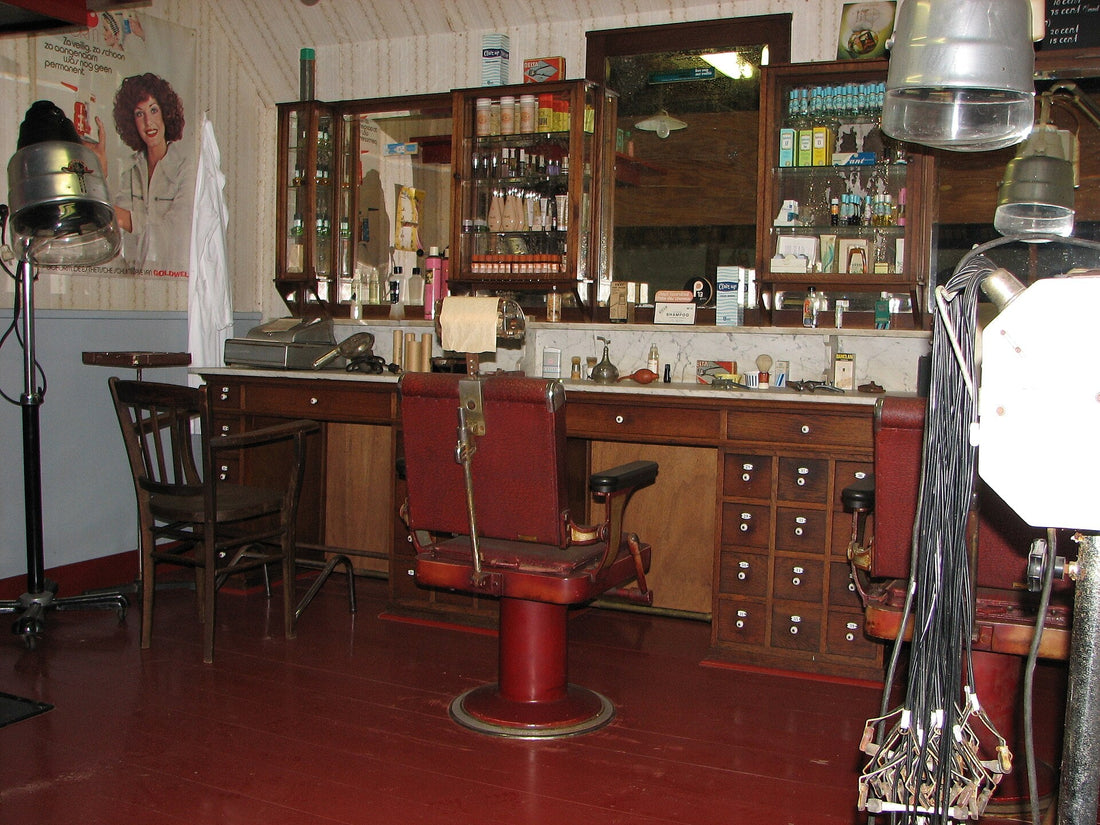 Interior of a traditional barbershop in early 20th-century Amsterdam, barbers at work with clients in chairs