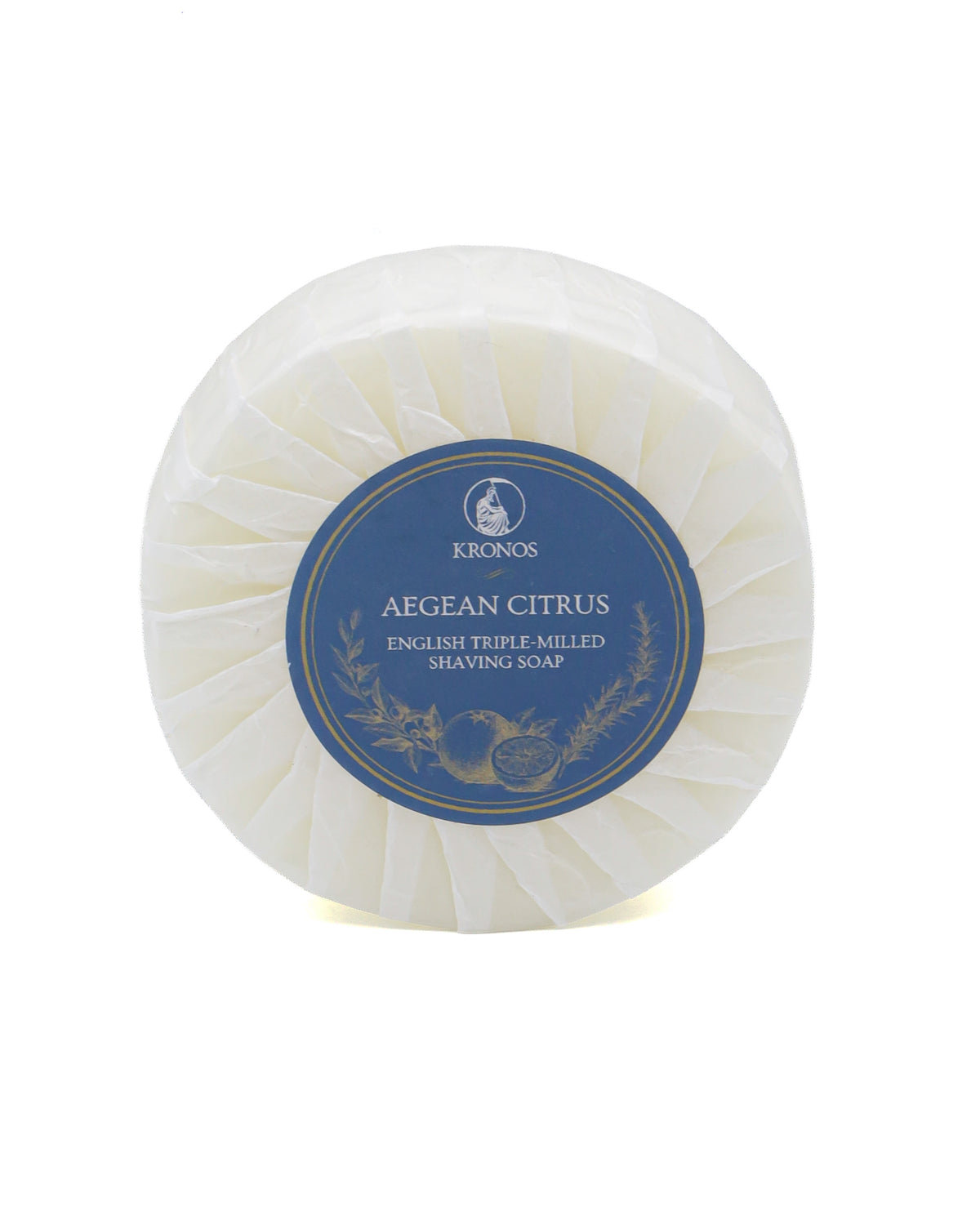 Kronos Aegean Citrus shaving soap, a round puck pleat-wrapped in white glassine paper with a navy and gold label, on a white background