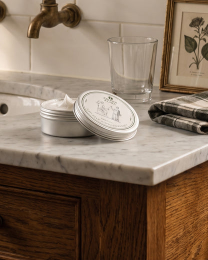 Aloe shaving cream open on a marble washstand in a bathroom