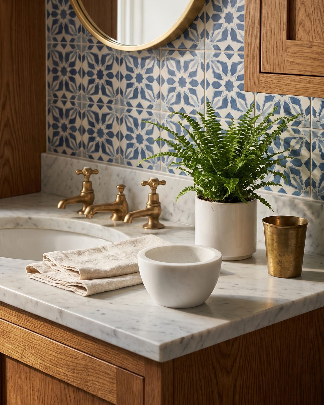 Kronos marble shaving bowl beside brass taps on a marble basin surround