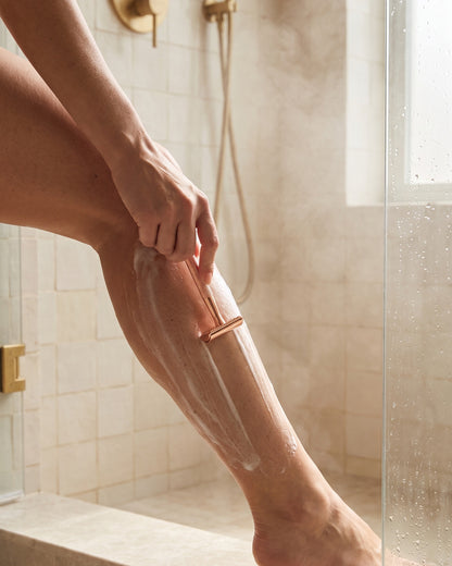 Shaving a leg with the rose gold razor in the shower