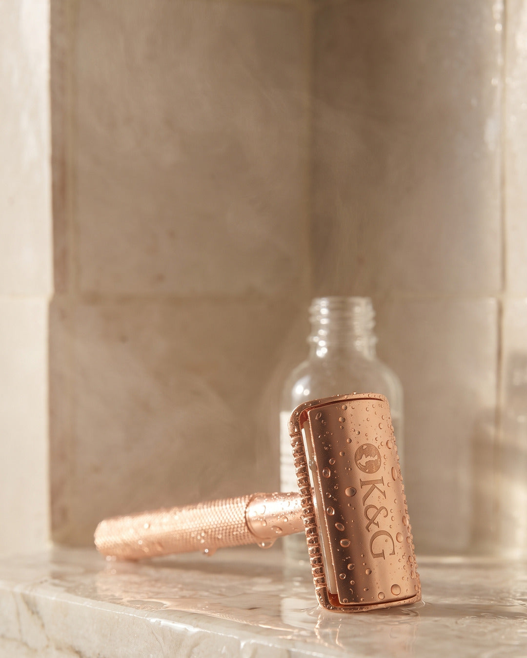 Rose gold razor wet in a shower niche, K&G handle detail