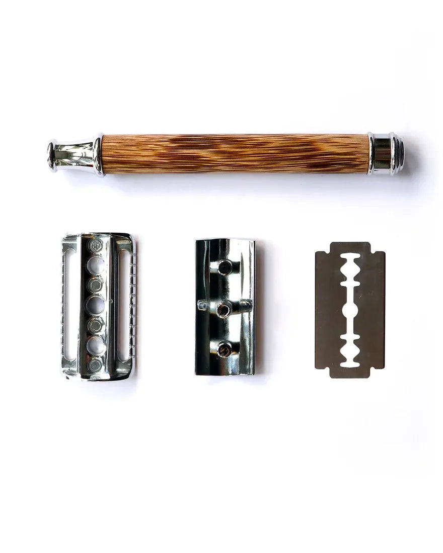 The bamboo-handled razor laid out in its three pieces beside a double-edge blade