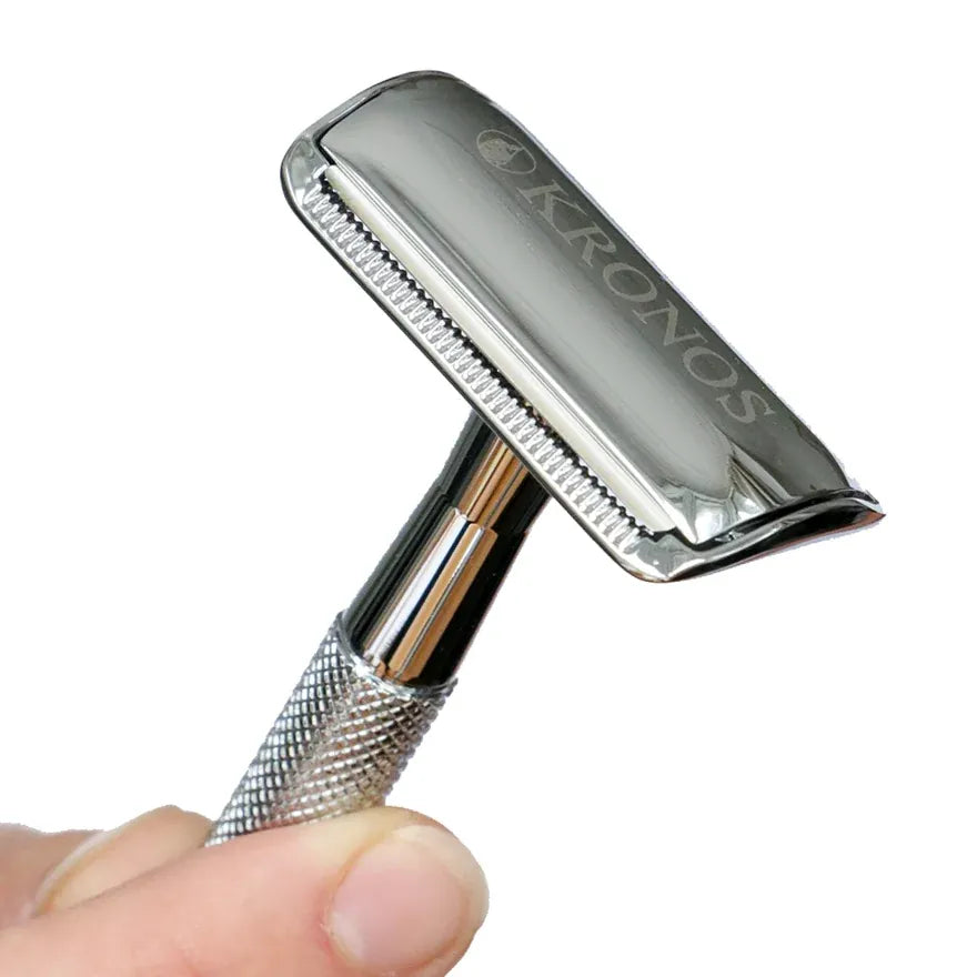 A hand holding the chrome Kronos safety razor